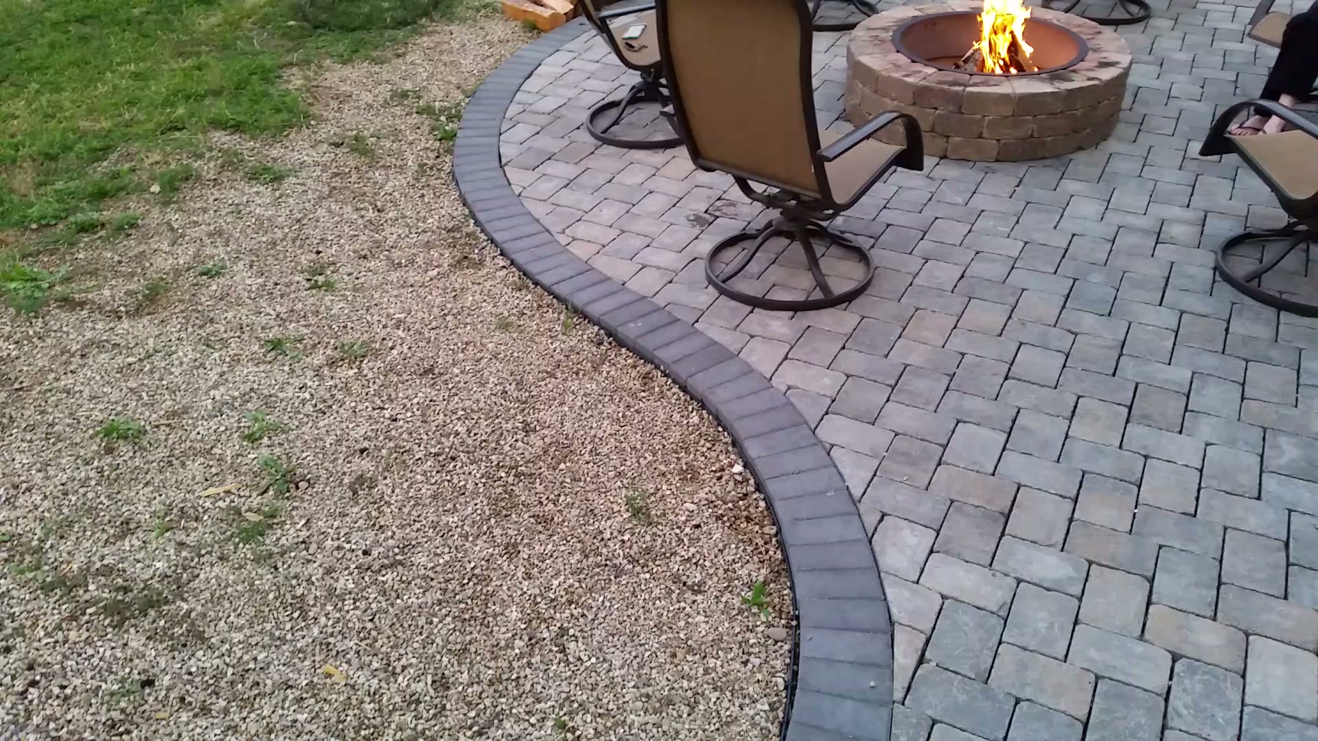 A finished paver patio with a decorative stone border